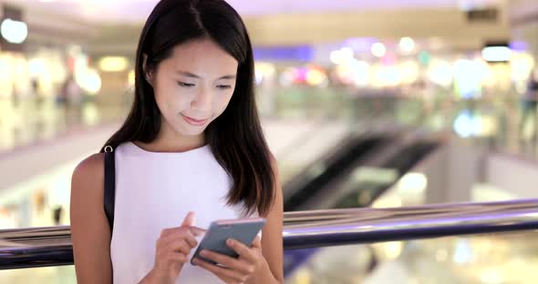 Woman using smart phone in shopping mall