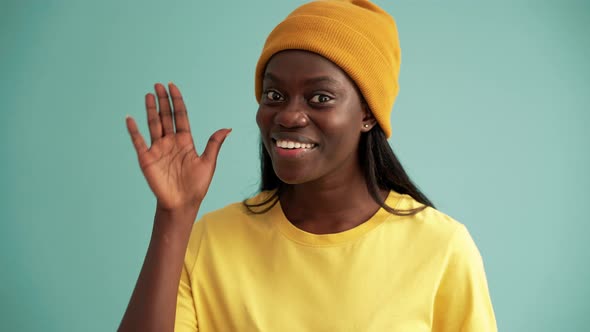 Surprised African woman showing hello gesture at the camera