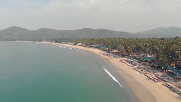 Palolem Beach idyllic shoreline and exotic landscape in Goa, India - Aerial Fly-over shot