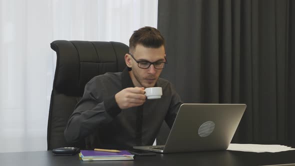 Businessman drinks coffee espresso at workplace. Corporate business concept