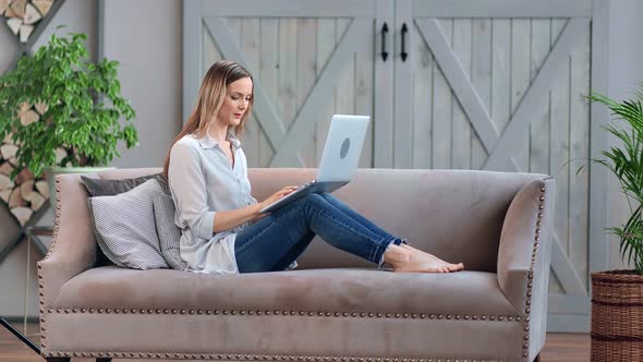 Smiling Beautiful Woman Sitting on Couch Use Laptop at Living Room