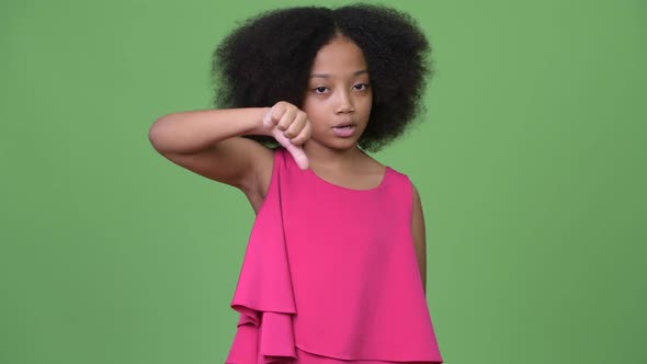 Young Cute African Girl with Afro Hair Giving Thumbs Down