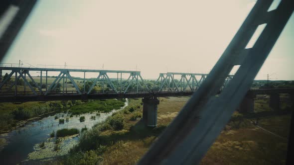 Bridge over the river from the window of a speeding train. Passion for travel. Iron bridge