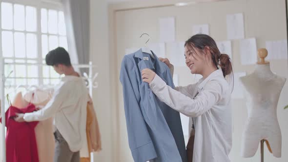 Young Asian Fashion Designers Looking At Clothes At Fashion Design Studio