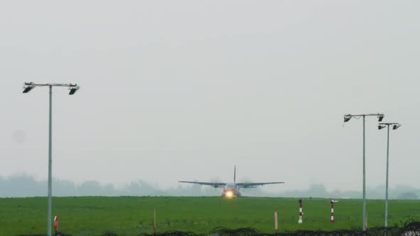 Military Transport Aircraft Landing at Rainy Weather