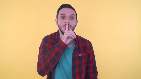 Man is Gesturing Hush Silence Gesture with a Finger on His Lips