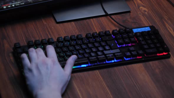 Gamer Typing on Backlight Keyboard Closeup Man Playing Video Game