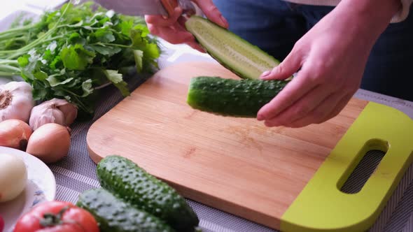 Closeup of Woman Slicing Cucumber on Wooden Cutting Board  Preparing Ingredient for Meal