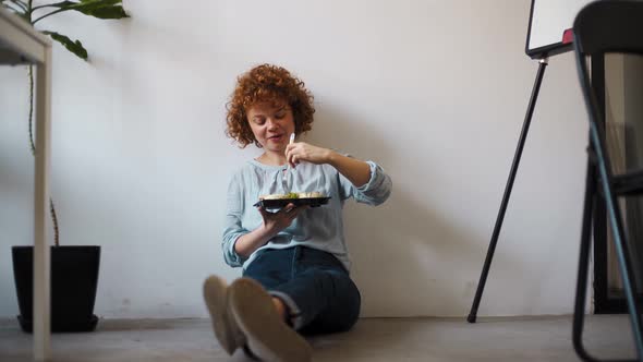 Young woman having lunch in office