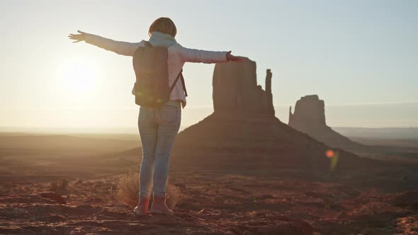Young Adventurous Woman on Rock Peak in Slow Motion Arms Raised in Joy Sunrise