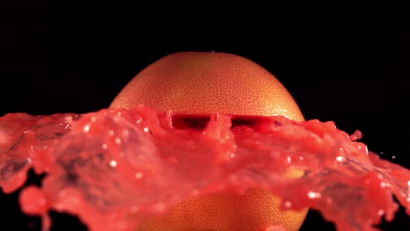 Fresh Grapefruit Fruit Squirting and Burst with Juice in Slow Motion in Black Background