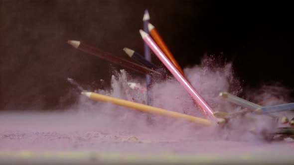 Pencil crayons falling in colorful powder, Ultra Slow Motion alt