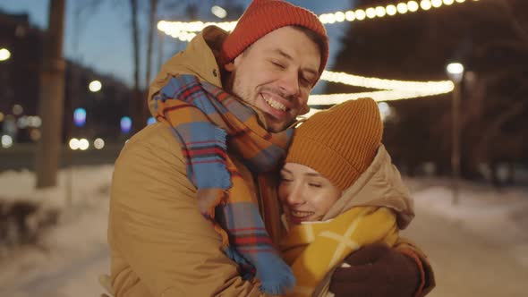 Portrait of Happy Couple on Street with Christmas Lights