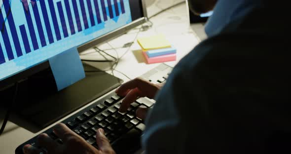 Side view of young Caucasian male executive working on computer at desk in modern office 4k