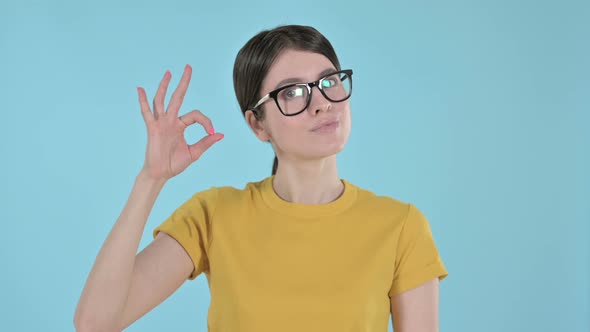 Cheerful Young Woman Showing OK Sign with Hand on Purple Background 