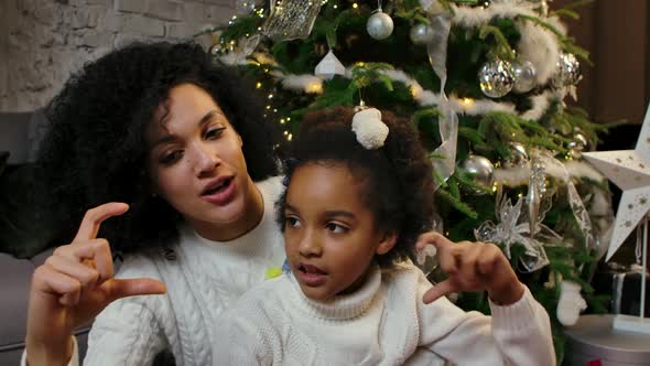 Portrait of Happy Smiling African American Mom and Little Daughter Looking at Camera and Making