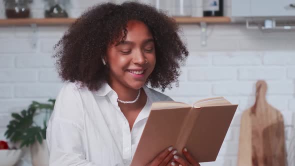 Contented Young Ethnic Hispanic Woman Reading Book Laughing