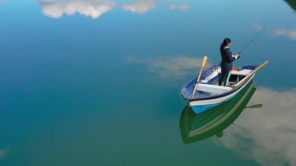 Woman on the Boat Catches a Fish on Spinning in Norway