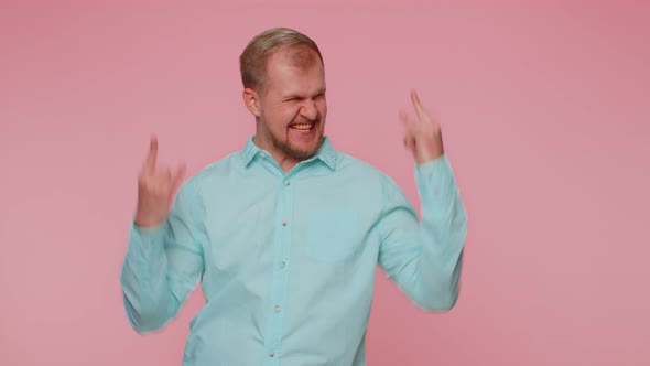 Overjoyed Happy Man Showing Rock n Roll Gesture By Hands Cool Sign Shouting Yeah with Crazy Face