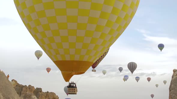 Hot Air Balloons fly over mountains in Cappadocia, Turkey