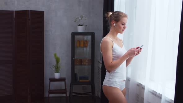 Young  girl is standing in front of the window