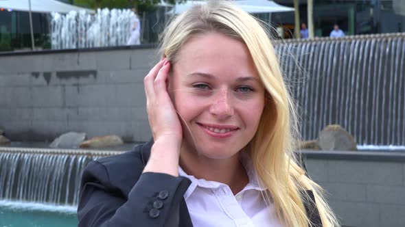 A Young Businesswoman Smiles at the Camera in an Urban Area - Closeup - Artificial Waterfalls