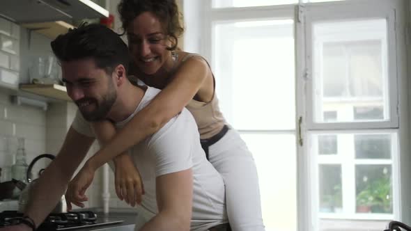 Beautiful European Couple is Having Fun Together and Laughing at Modern Kitchen Spbd