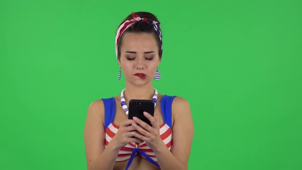 Portrait of Beautiful Girl in a Swimsuit Is Texting on Her Phone. Green Screen
