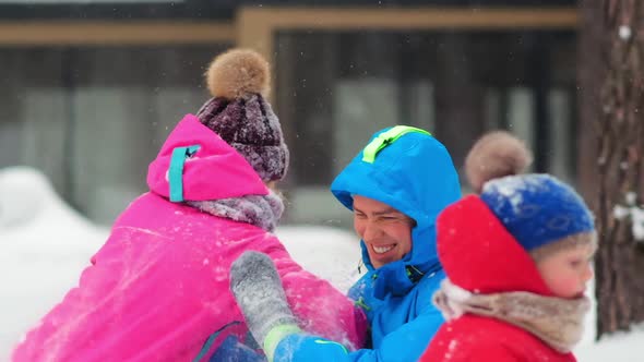 Joyful Couple Falls on Snow Laughing on Cold Winter Day