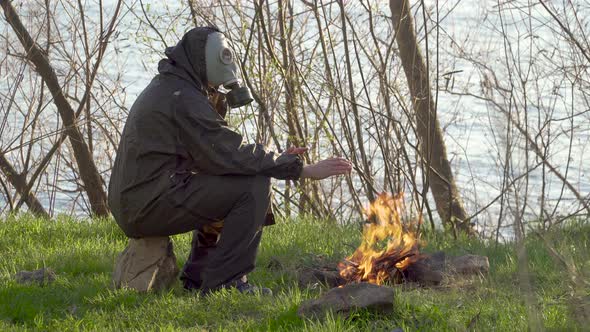 A Man in a Gas Mask Near a Fire