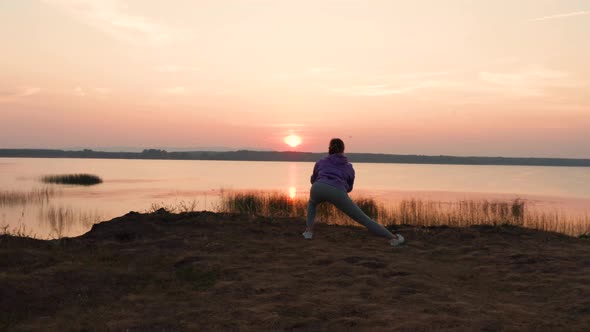 A Girl Does Fitness on a Hill at Sunset