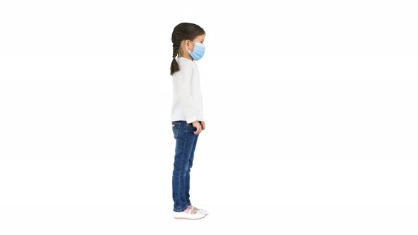 Little Girl Taking Her Face Mask Off and Smiling at Camera on White Background