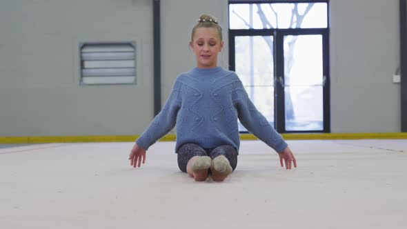 Teenage female gymnast performing at sports hall