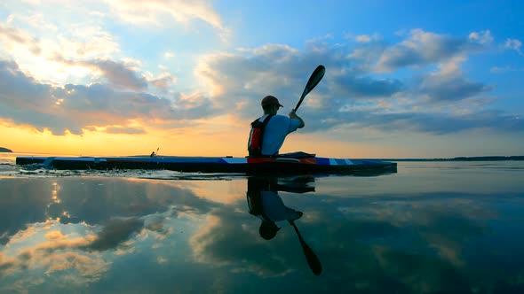 Paddlers Are Crossing Water Surface on Kayaks