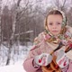 Cute girl in a traditional Russian headscarf and mittens playing on spoons on winter forest backgrou - VideoHive Item for Sale