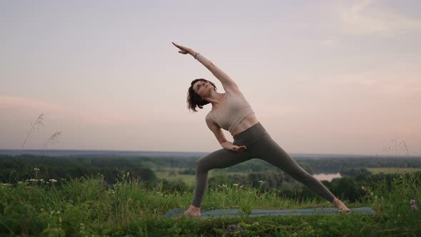 Young Woman Preforms Yoga in Mountains in Morning Light