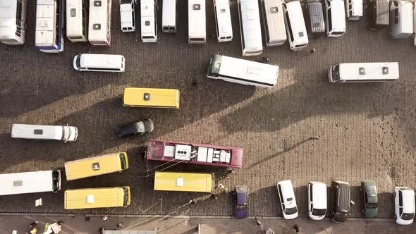 Aerial footage of many cars and buses moving on a busy city street.