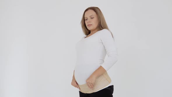 Pregnant Fairskinned Woman Wears a Bandage for Pregnant Women