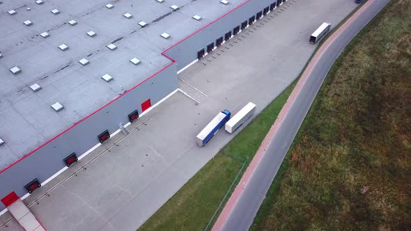 Truck is Driving to Logistics Center. Aerial Shot./ Storage Building/ Loading Area where Many Trucks
