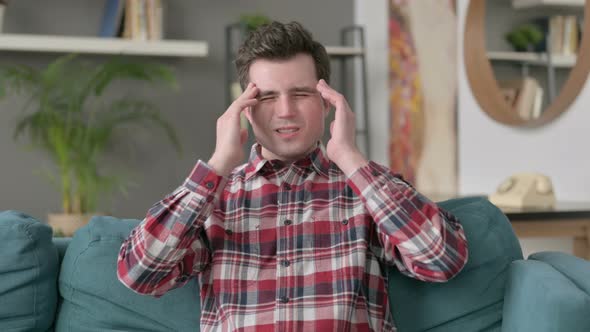 Portrait of Man Having Headache While Sitting on Sofa