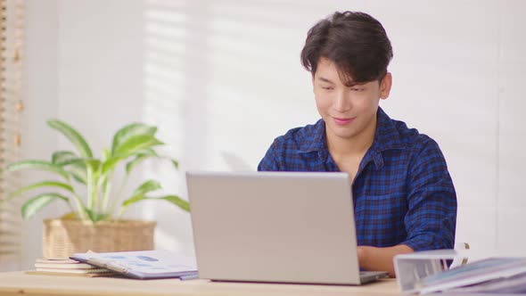 Entrepreneur handsome business asian man wear blue shirt working online on desk table