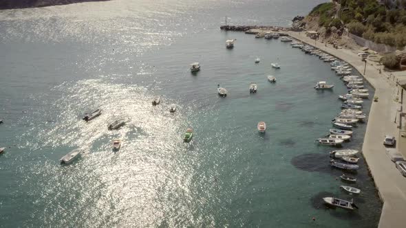 Aerial view of fishing boats parked on seashore in Greece.