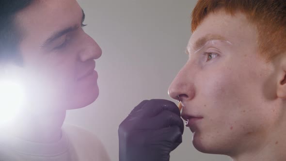 Attractive Man Brow Master Drawing Guiding Lines on the Eyebrows of His Male Client