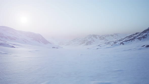 Aerial Landscape of Snowy Mountains and Icy Shores in Antarctica