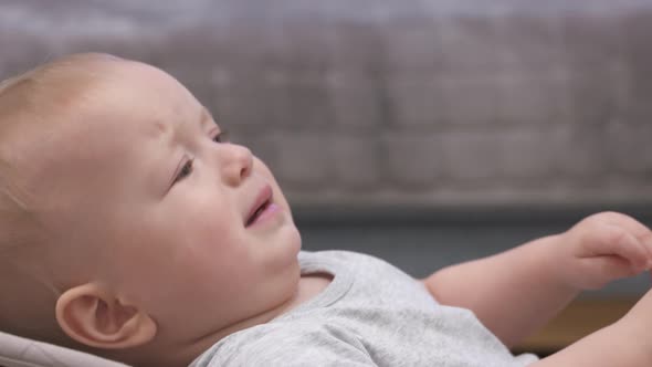 Caucasian 9Monthold Baby Boy is Upset and Crying Dad Handing Mobile Device to Child to Calm Him Down