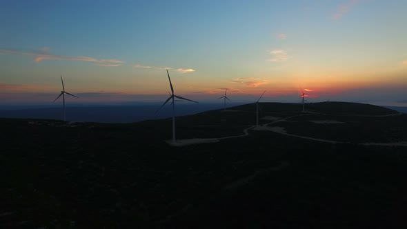 Aerial view of white elegant windmills at sunset