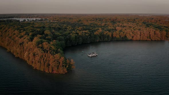 Cinematic aerial view from drone flying over boats floating on Mindemoya Lake, ON, Canada at dawn