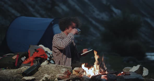 Charismatic Curly Hair Young Guy at Camping Beside