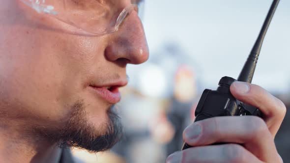 Extreme Closeup Mouth of Bearded Male Construction Worker Talking Using Walkie Talkie Side View