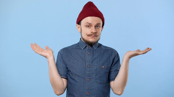Portrait of Hipster Man 20s Wearing Hat and Denim Shirt Throwing Up Hands and Shrugging Like Have No